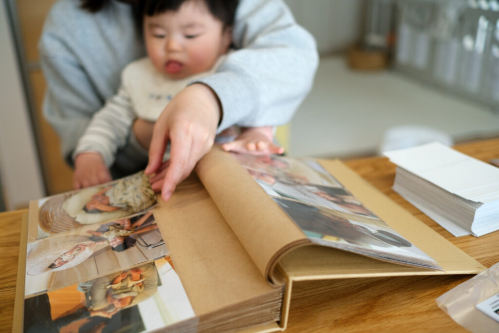息子を抱っこしながら家族でフォトアルバムを作っている様子