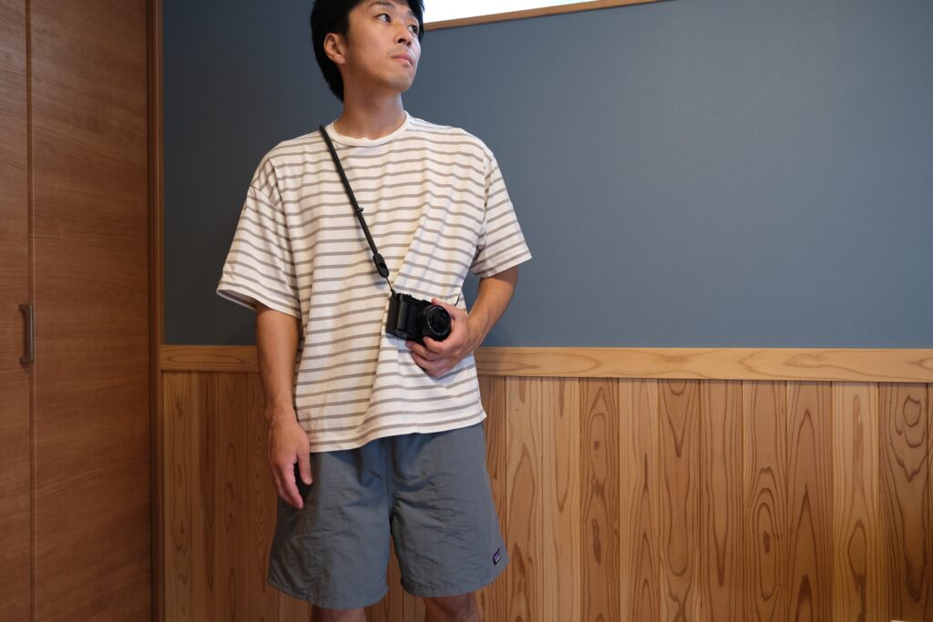 襷掛けの状態でFUJIFILM X-E5を構えている様子