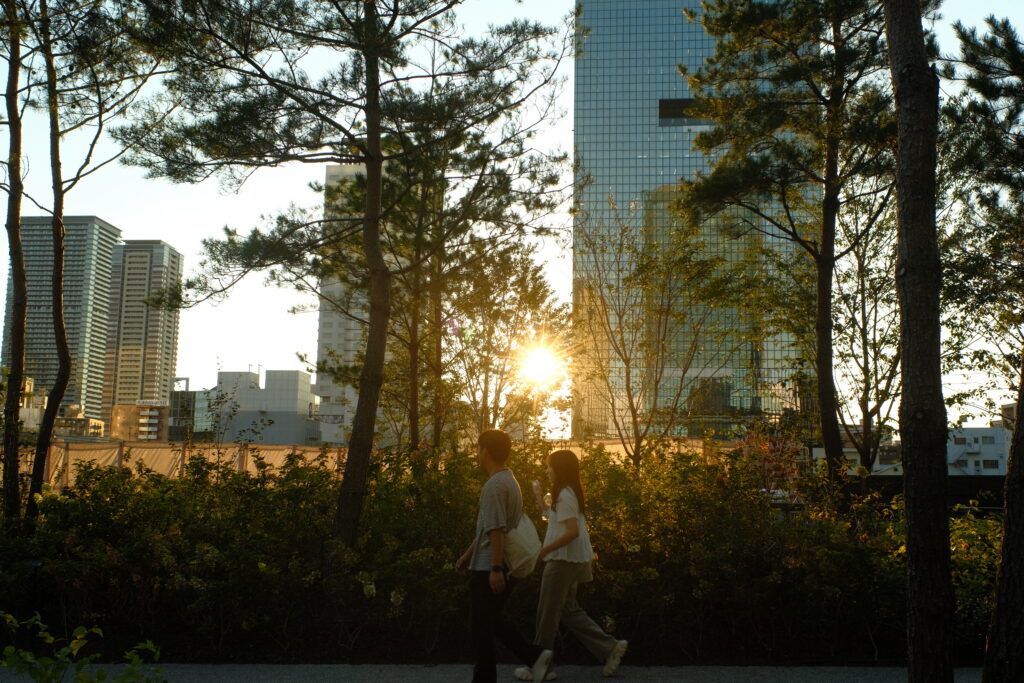 夕暮れ時の都会を富士フイルムのカメラで撮った写真。カップルが写っており、ハイコントラストなフィルムシミュレーションが効果的に使われている。