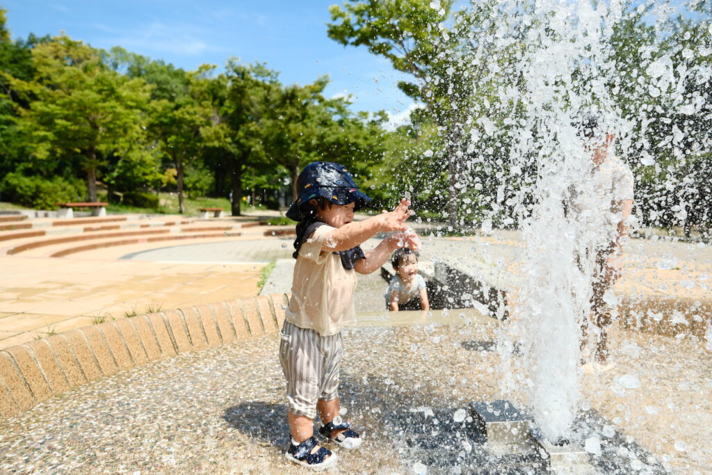 公園の噴水ではしゃぐ子供たち
